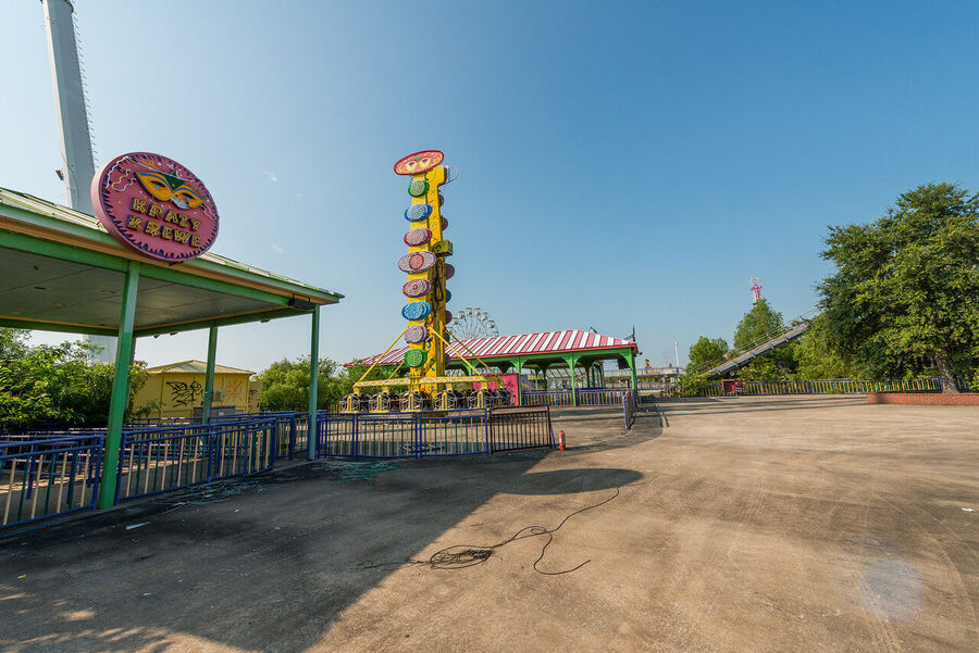 Fine art urban exploration photograph of abandoned Six Flags New Orleans roller coaster structure, nature reclaiming concrete and steel