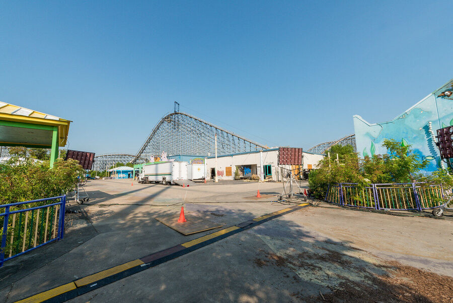 Large format fine art print of the derelict Six Flags New Orleans park at golden hour, rust and vegetation creating an atmosphere of quiet desolation