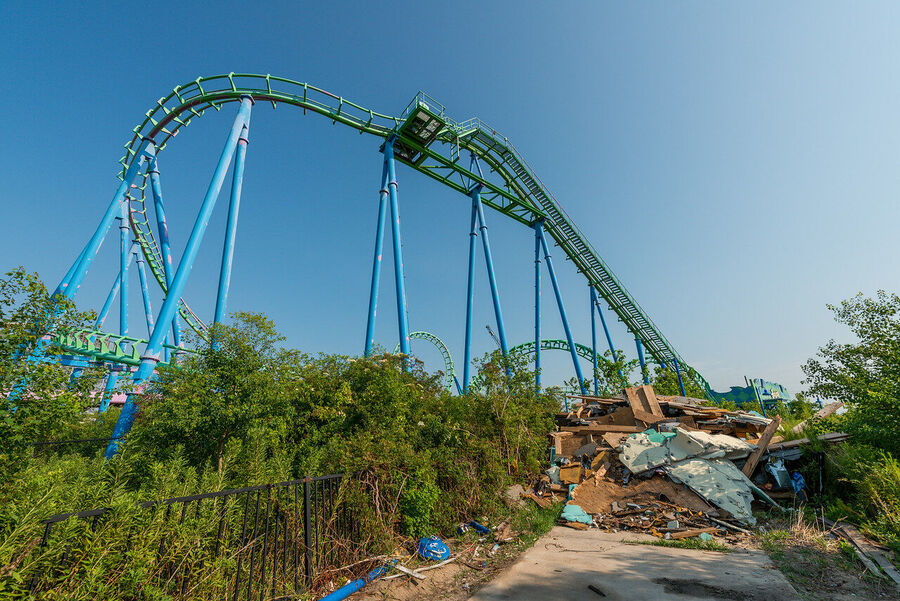 Fine art urban exploration photograph of abandoned Six Flags New Orleans roller coaster structure, nature reclaiming concrete and steel