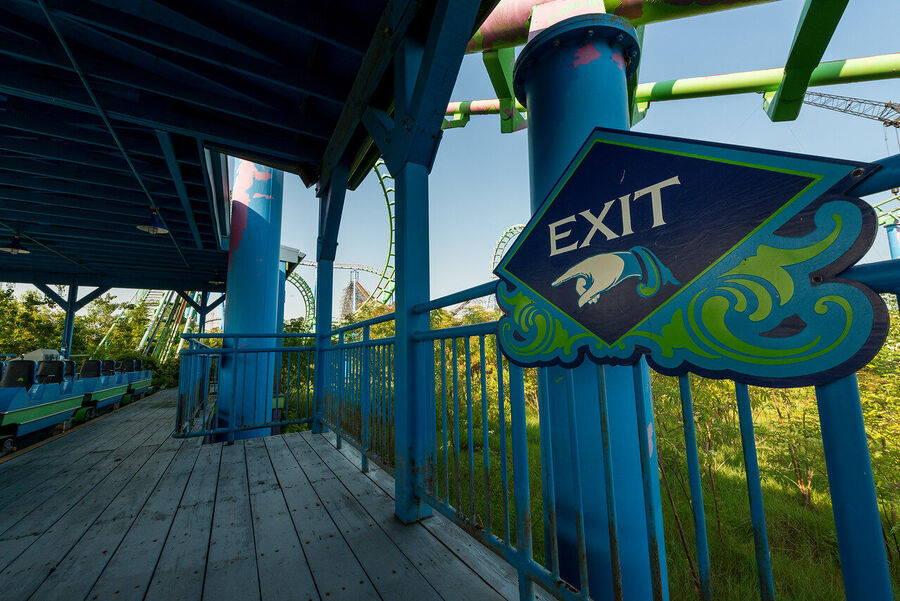 Fine art urban exploration photograph of abandoned Six Flags New Orleans roller coaster structure, nature reclaiming concrete and steel