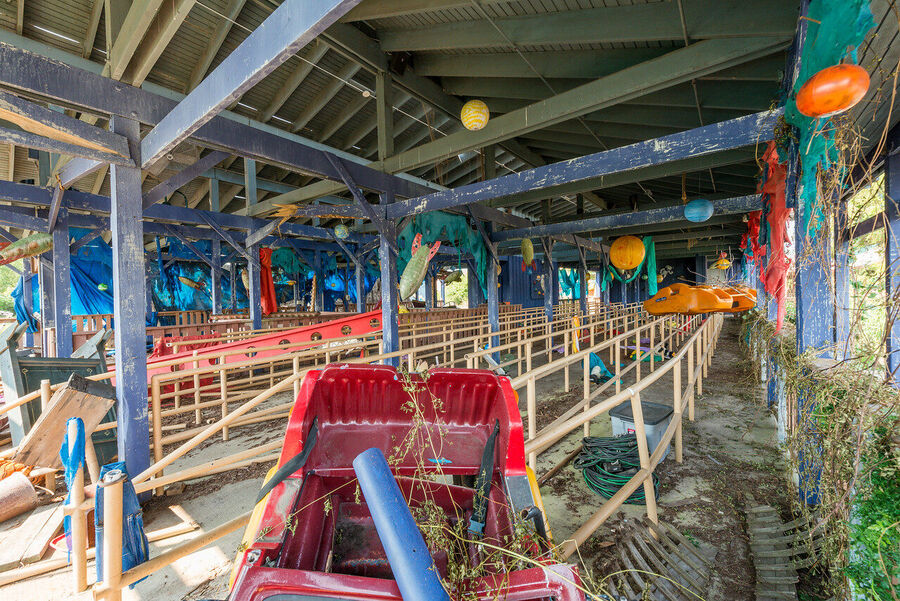 Large format fine art print of the derelict Six Flags New Orleans park at golden hour, rust and vegetation creating an atmosphere of quiet desolation