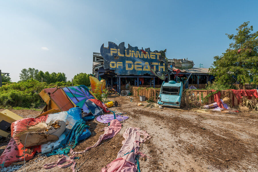 Fine art urban exploration photograph of abandoned Six Flags New Orleans roller coaster structure, nature reclaiming concrete and steel