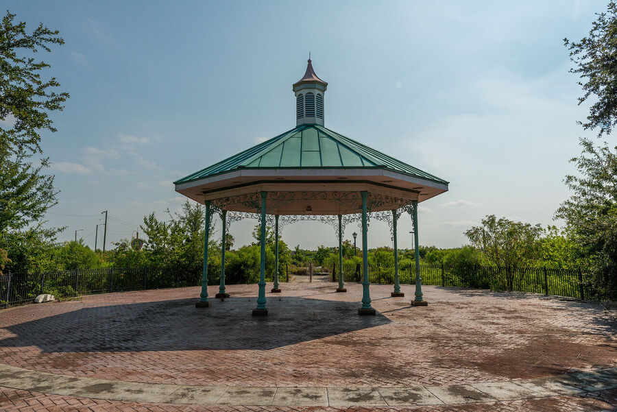 Fine art urban exploration photograph of abandoned Six Flags New Orleans roller coaster structure, nature reclaiming concrete and steel