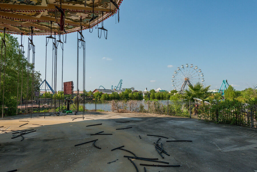 Large format fine art print of the derelict Six Flags New Orleans park at golden hour, rust and vegetation creating an atmosphere of quiet desolation