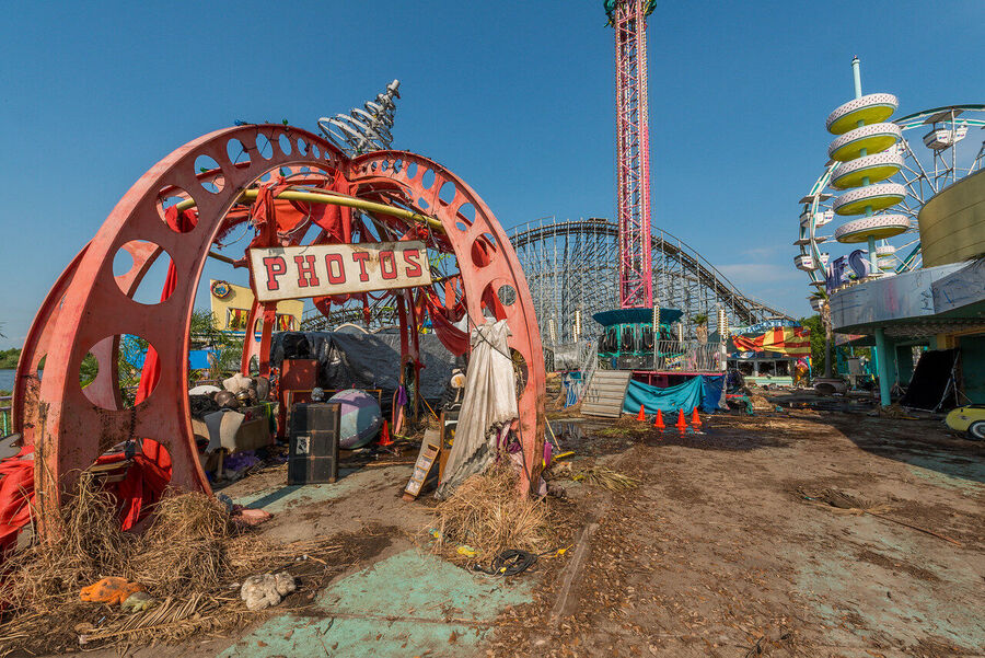 Large format fine art print of the derelict Six Flags New Orleans park at golden hour, rust and vegetation creating an atmosphere of quiet desolation