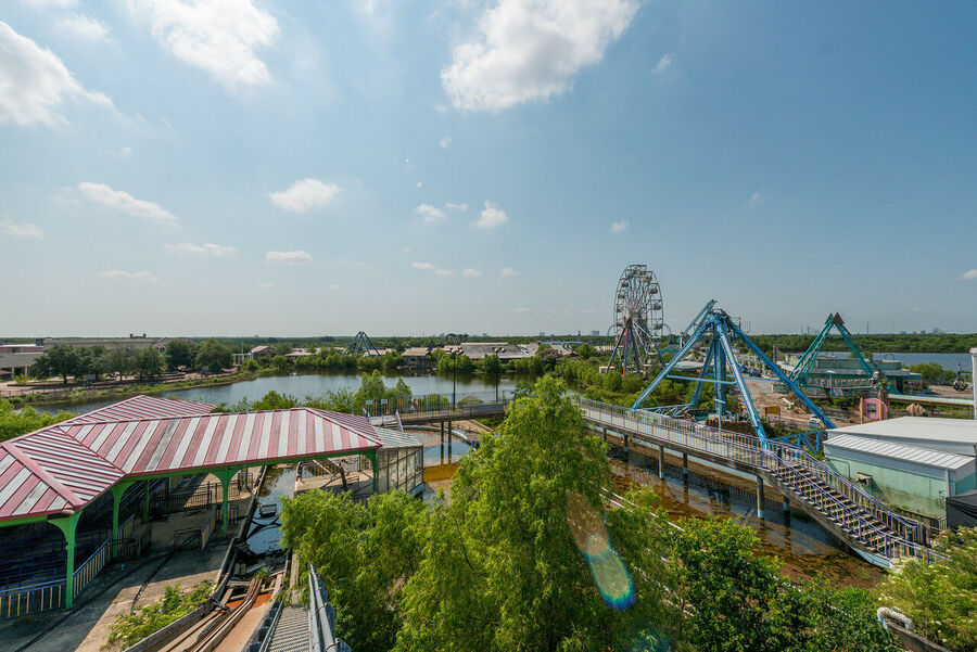 Large format fine art print of the derelict Six Flags New Orleans park at golden hour, rust and vegetation creating an atmosphere of quiet desolation