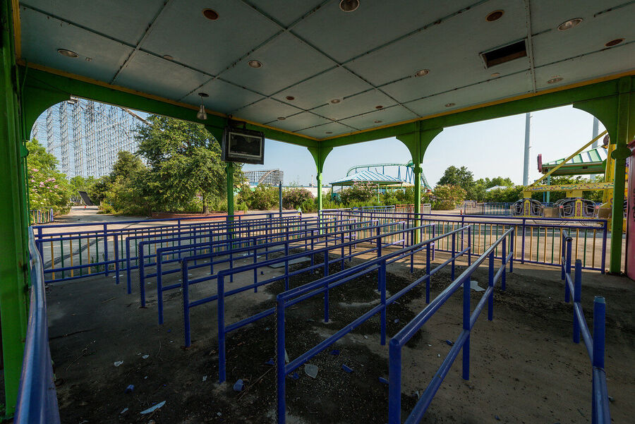 Large format fine art print of the derelict Six Flags New Orleans park at golden hour, rust and vegetation creating an atmosphere of quiet desolation