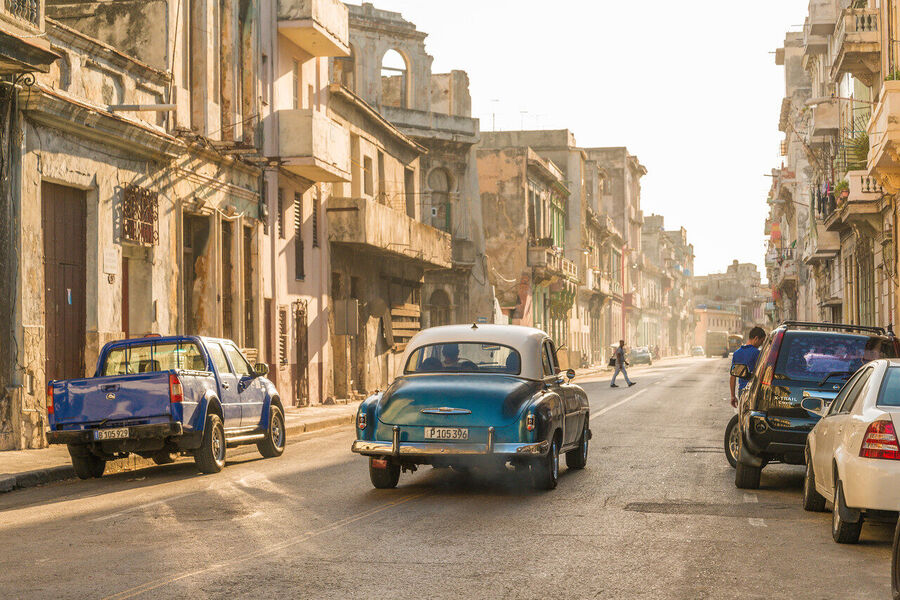 Fine art street photography print of colorful vintage taxis idling along a Havana boulevard, the city's timeless patina on full display