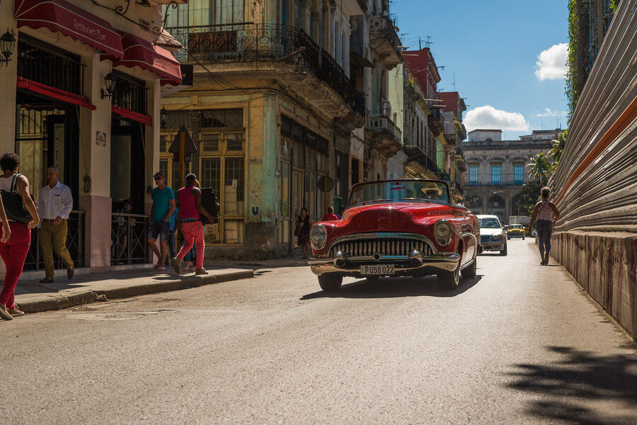Fine art street photography print of colorful vintage taxis idling along a Havana boulevard, the city's timeless patina on full display