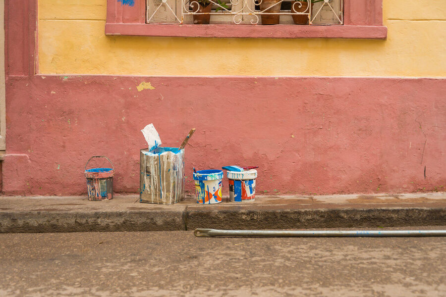 Fine art documentary print capturing everyday Havana life — a quiet street scene of extraordinary human warmth and architectural grandeur