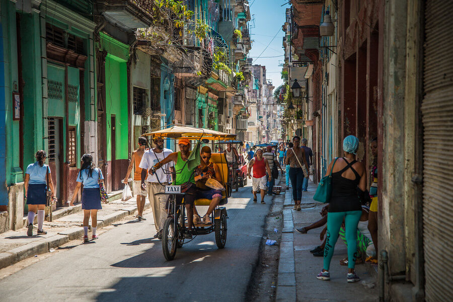 Fine art street photography print of colorful vintage taxis idling along a Havana boulevard, the city's timeless patina on full display