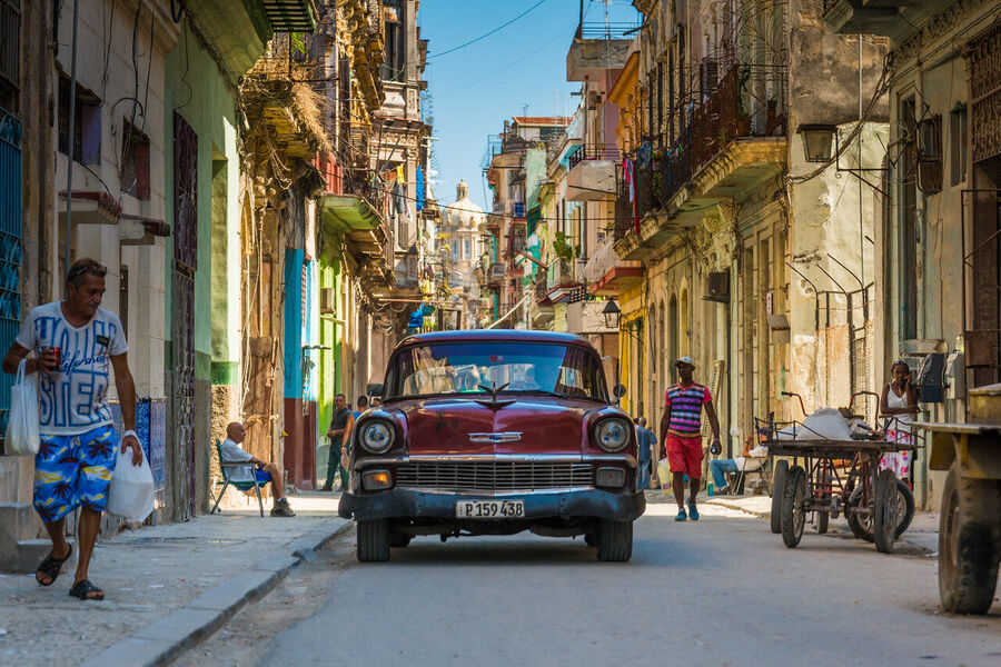 Fine art documentary print capturing everyday Havana life — a quiet street scene of extraordinary human warmth and architectural grandeur