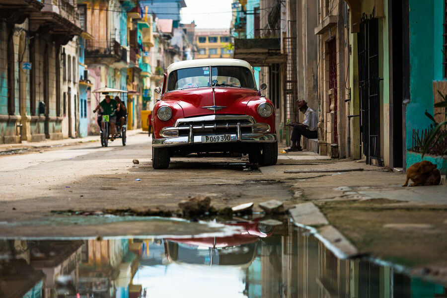 Street fine art photography print of Havana's crumbling colonial architecture bathed in late afternoon sun, shadows long on cobblestone streets