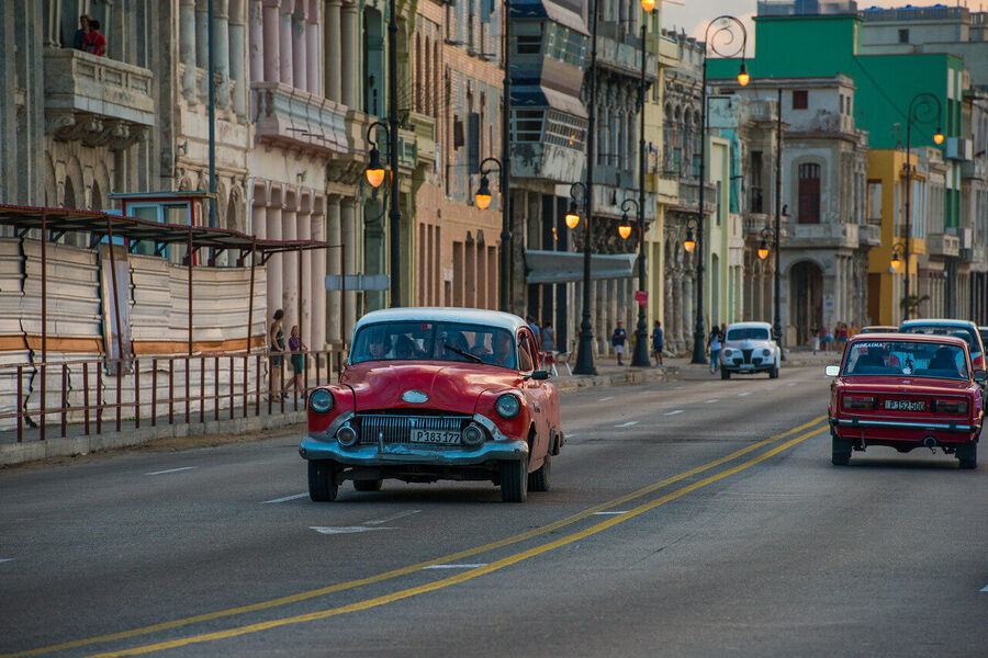 Fine art documentary print capturing everyday Havana life — a quiet street scene of extraordinary human warmth and architectural grandeur
