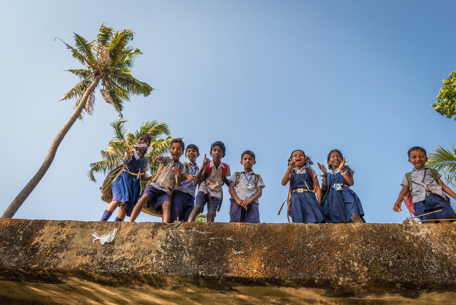 Fine art photograph of a young Indian student in school uniform, clear afternoon light making her direct gaze impossible to look away from