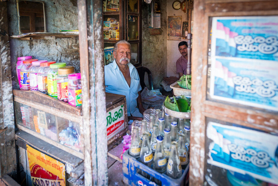 Fine art documentary photograph of a craftsman at work in an Indian market, deep concentration visible in the quality of the available light