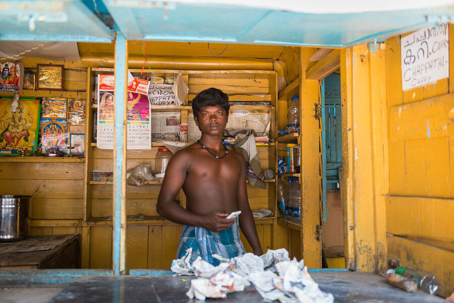 Fine art documentary photograph of a craftsman at work in an Indian market, deep concentration visible in the quality of the available light