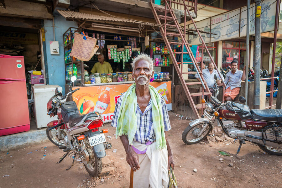 Fine art documentary photograph of a craftsman at work in an Indian market, deep concentration visible in the quality of the available light