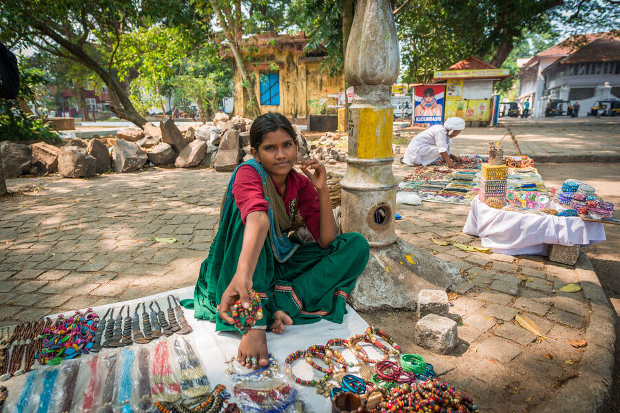 Fine art documentary photograph of a craftsman at work in an Indian market, deep concentration visible in the quality of the available light