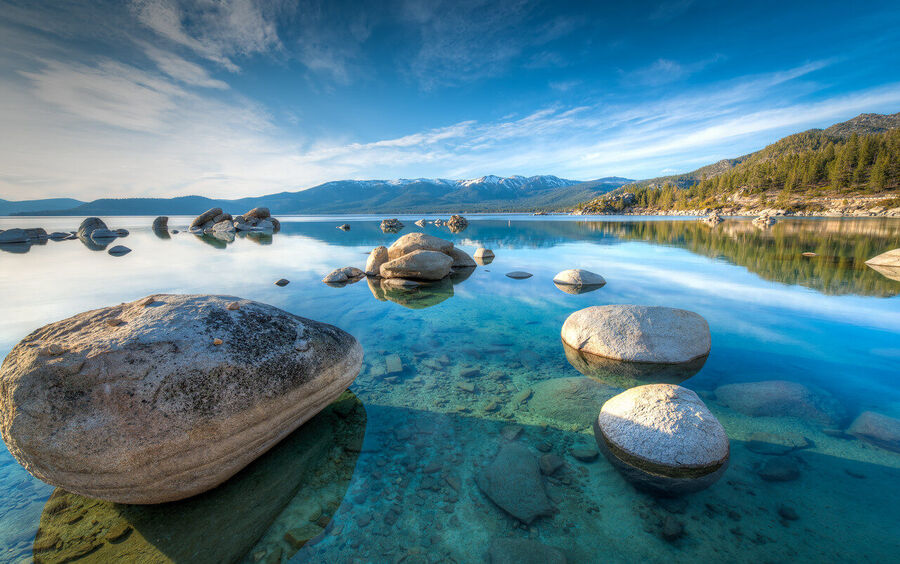 Fine art nature print of Lake Tahoe's rocky eastern shoreline with crystal-clear submerged stones visible through the water at dawn