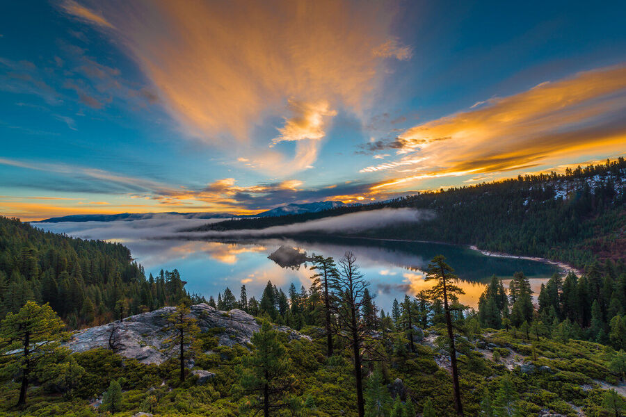 Dramatic fine art landscape photograph of Lake Tahoe's eastern shore at dusk, storm light turning the water a deep pewter-blue