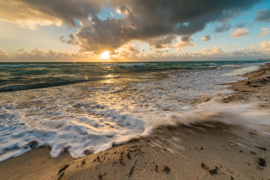 Large format fine art photograph of South Beach at sunrise, tropical storm clouds dispersing as warm light breaks across the Atlantic