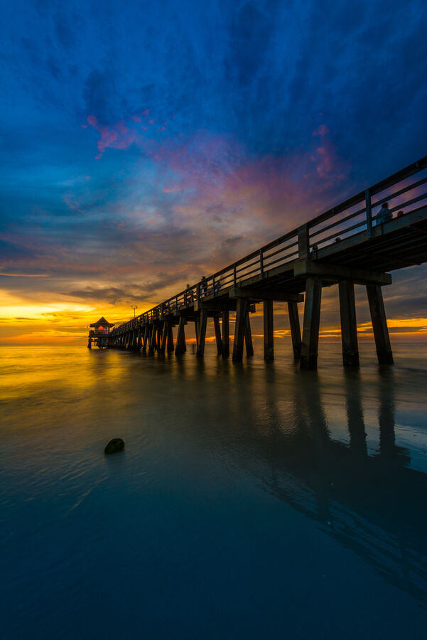 Large format fine art photograph of Naples Beach at golden hour, wet sand reflecting the sky in a perfect geometric composition