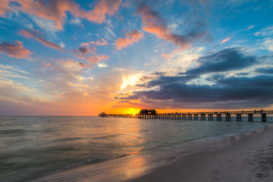 Fine art seascape print of the Gulf of Mexico at Naples at dusk, cumulus clouds building offshore as the last light saturates the horizon