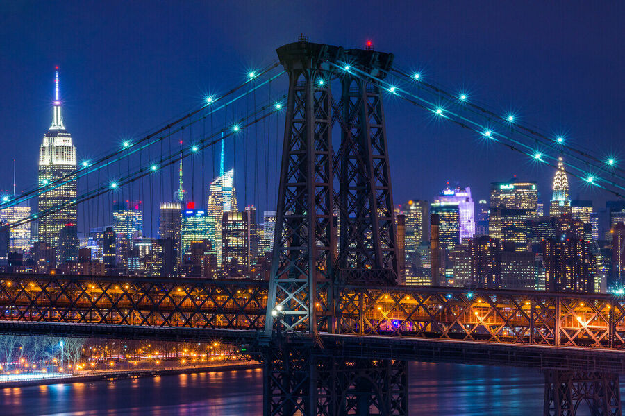 Fine art night print of the Manhattan Bridge from the Brooklyn waterfront, the suspension span doubled in mirror-flat river water below